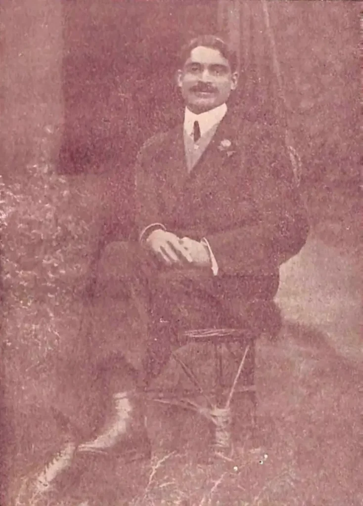 Dr. Bidhan Chandra Roy taken in 1911, showing him as a young man in formal Western attire with a calm and serious expression, posed for a studio portrait.