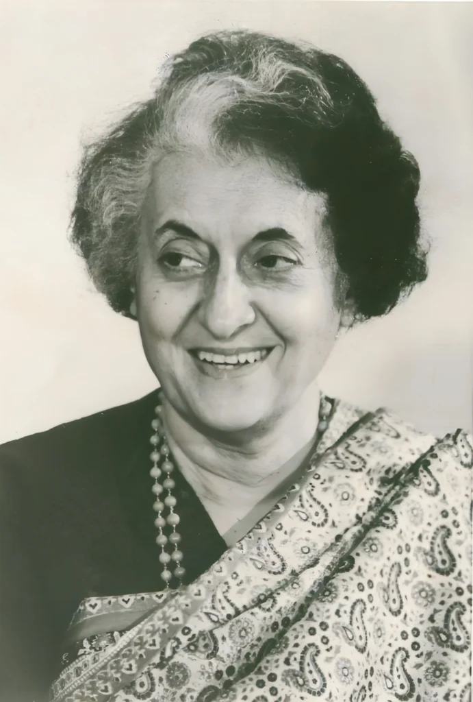 Smiling portrait of Indira Gandhi, India’s first woman Prime Minister, wearing a patterned saree and necklace