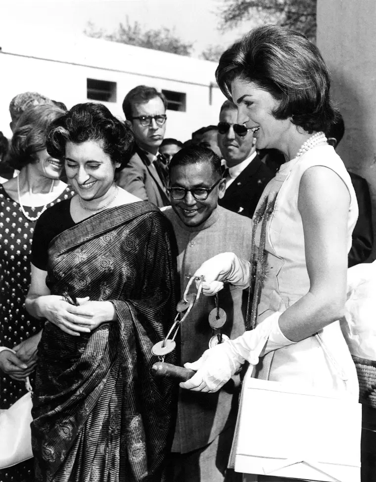 Jacqueline Kennedy standing beside Indian Prime Minister Indira Gandhi during a meeting, both women dressed formally and engaged in conversation.