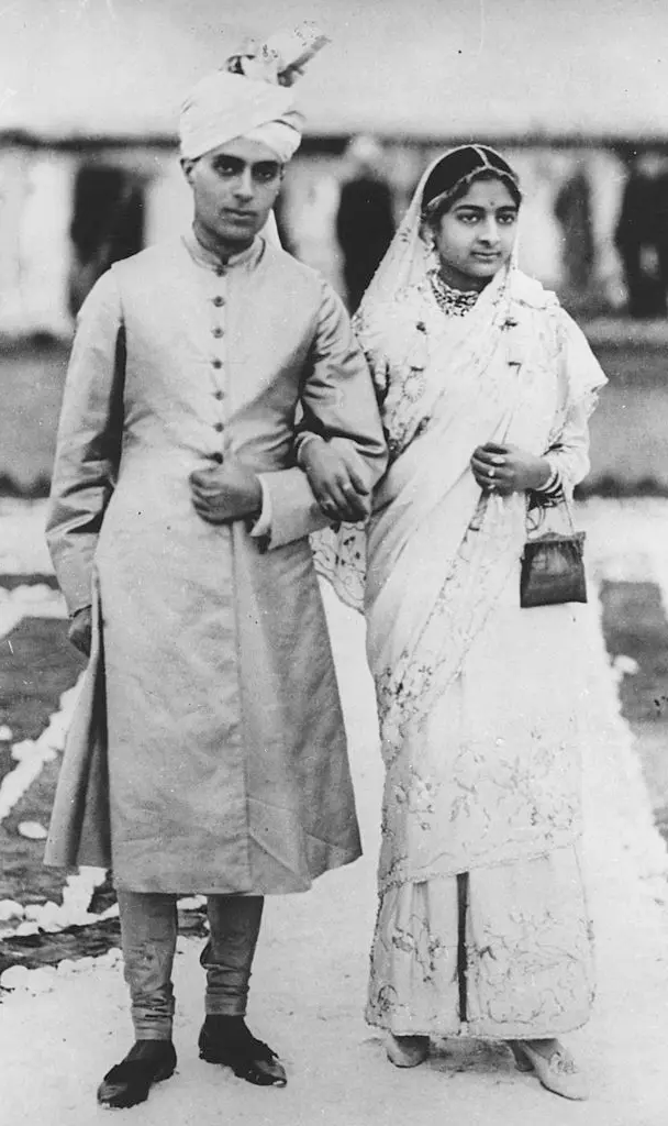 a young Indian couple dressed in traditional wedding attire.