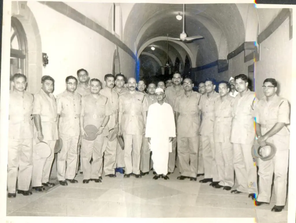 Lal Bahadur Shastri (center, in white swaraj-style clothing), surrounded by officers of the Indian Police Service 1955 batch, all posed under an arched stone structure at Mount Abu, India, dated 5 June 1963.