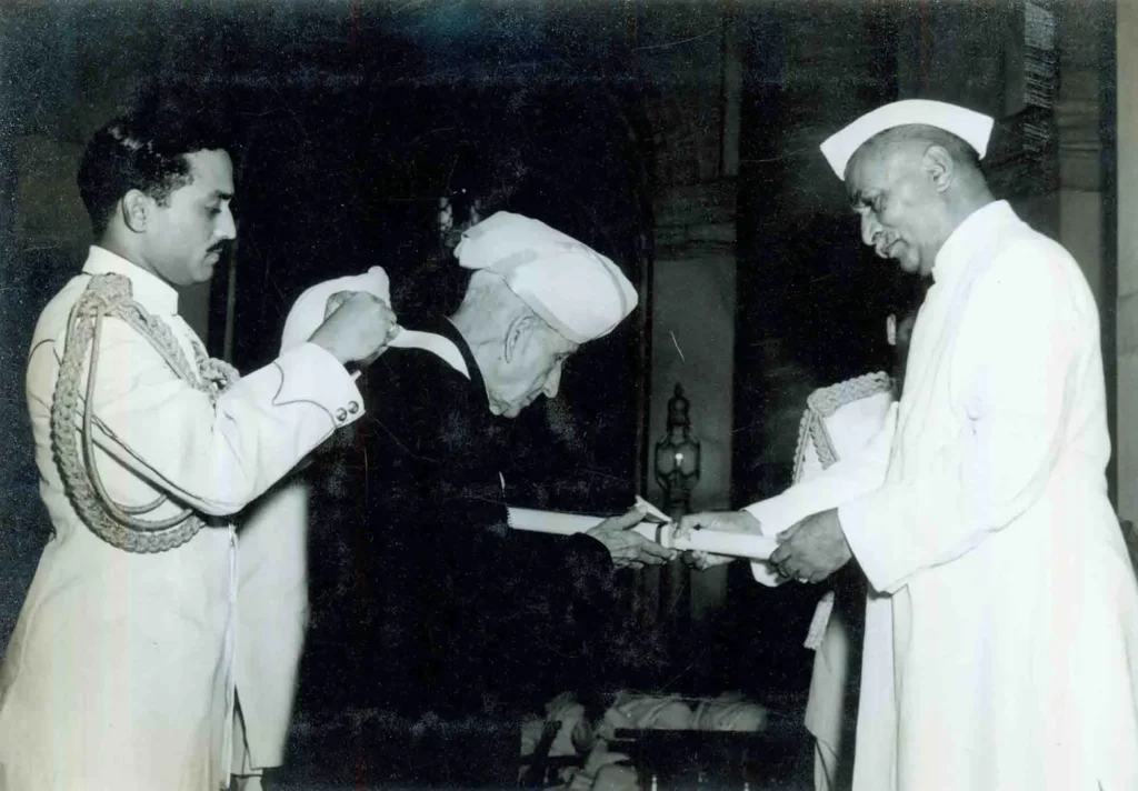 President Dr. Rajendra Prasad presenting the Bharat Ratna award to Sir M. Visvesvaraya, who is dressed in traditional attire and turban, during a formal ceremony.
