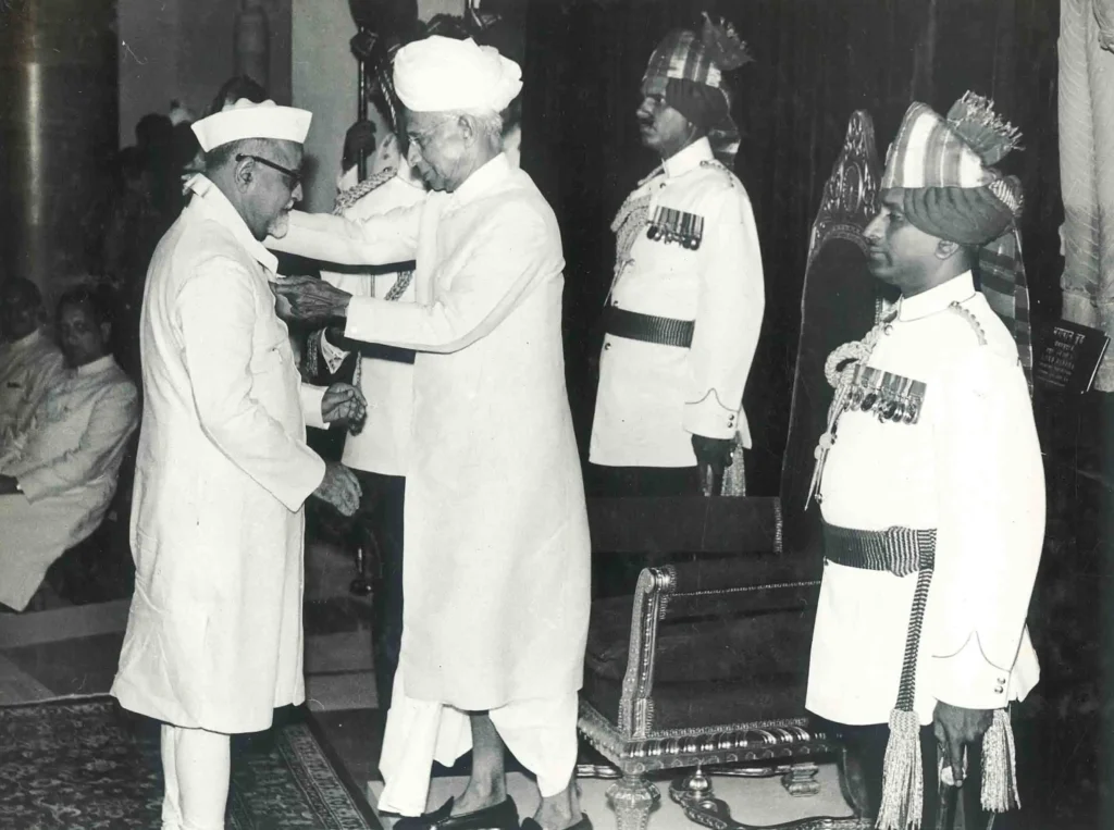 Dr. Zakir Husain, Vice President of India, receiving the Bharat Ratna from President Dr. Sarvepalli Radhakrishnan during a formal ceremony; both are dressed in traditional attire, with Radhakrishnan presenting the award to Husain.