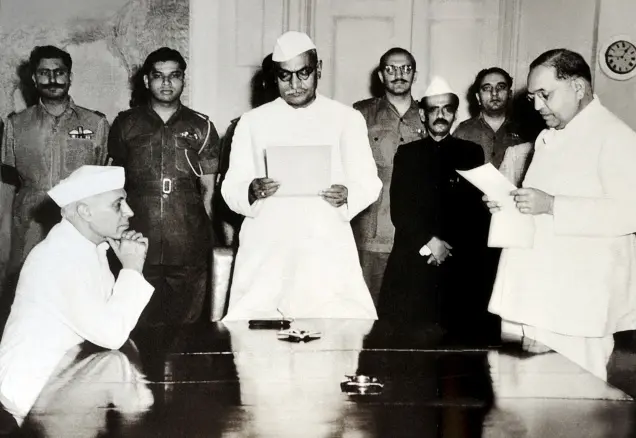 Dr. B. R. Ambedkar being sworn in as India's first Law Minister by President Dr. Rajendra Prasad, with Prime Minister Jawaharlal Nehru observing.