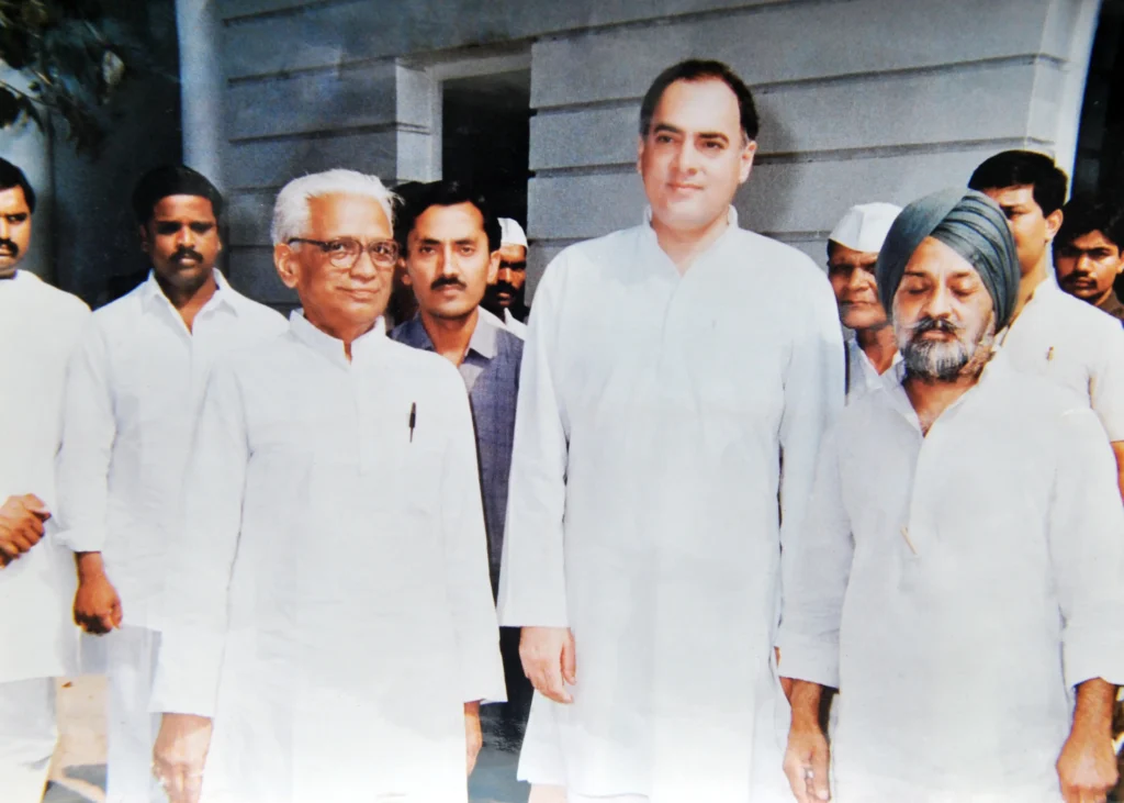 Indian political figures, including Rajiv Gandhi standing prominently in the center wearing a white kurta.