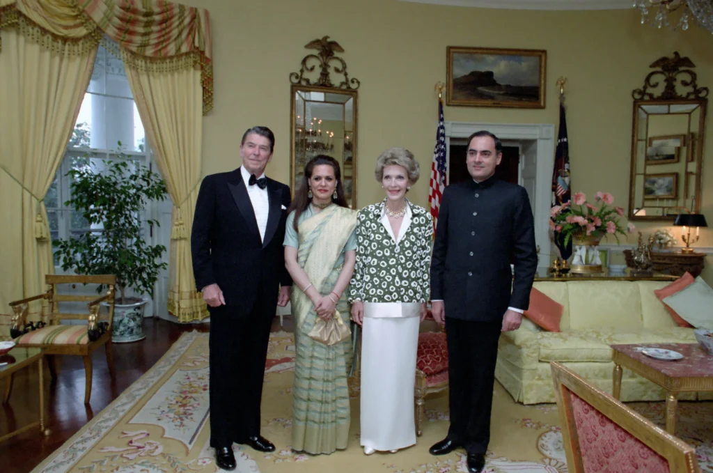 Ronald Reagan, Nancy Reagan, Rajiv Gandhi, and Sonia Gandhi standing together indoors, dressed formally.