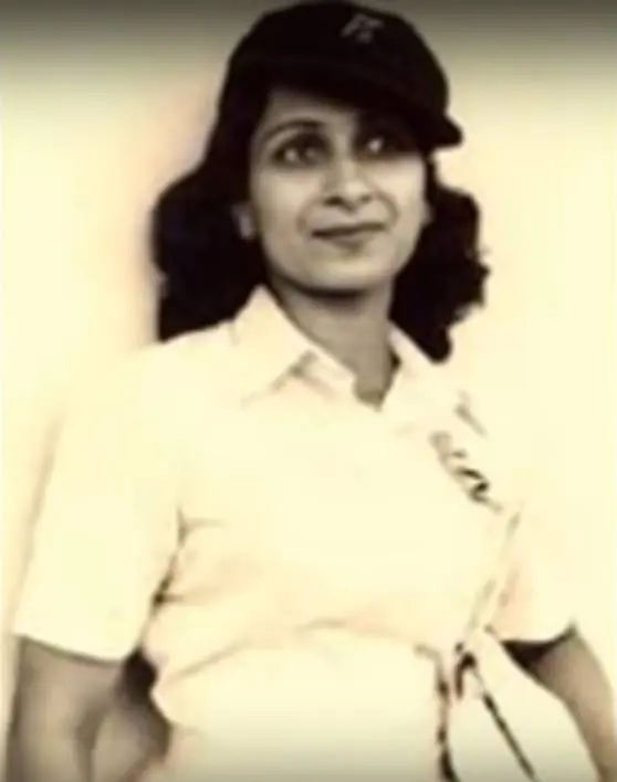 Young Aruna Asaf Ali  wearing a light-colored shirt and a dark cap, looking to the side with a slight smile.