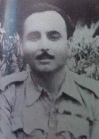 Black-and-white portrait of a man with a mustache wearing a military uniform, photographed outdoors.