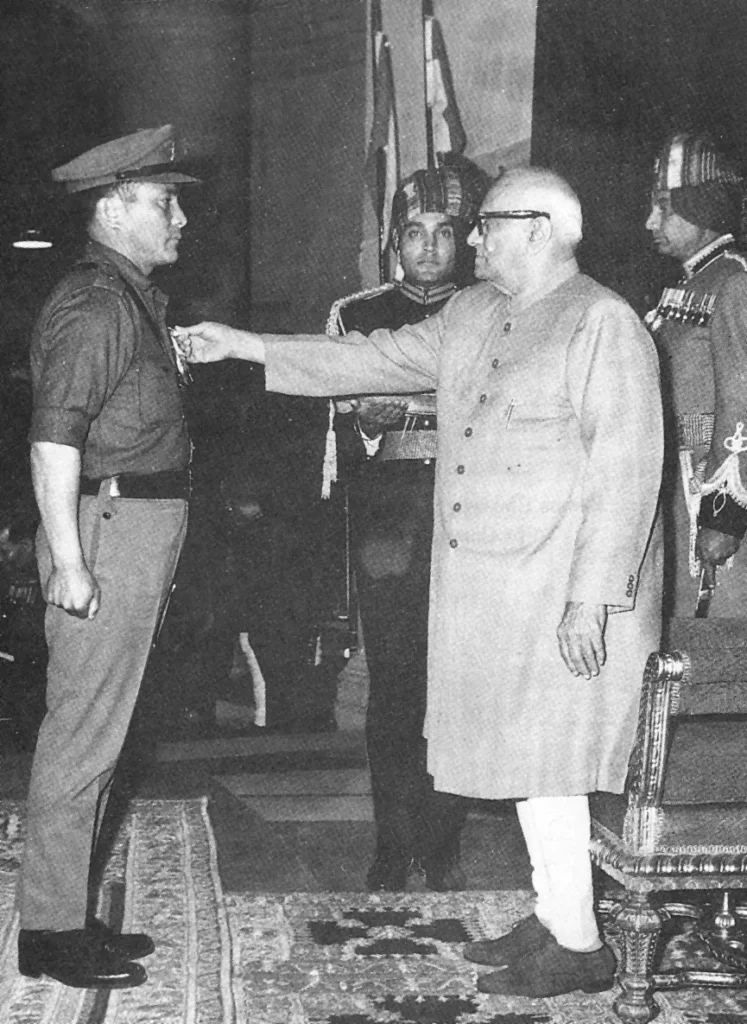 Black-and-white photograph of an Indian Army officer receiving a military medal during a formal award ceremony.