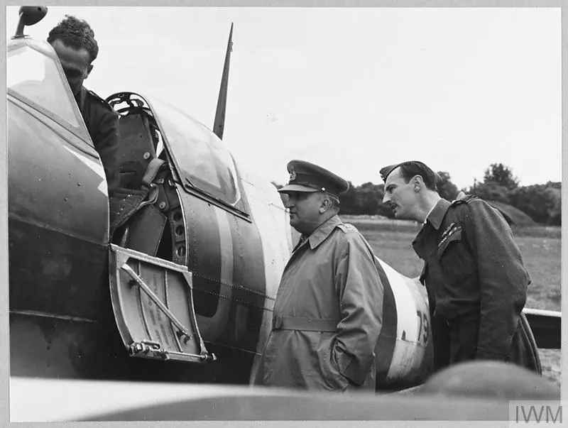 Black-and-white photograph of military officers inspecting a fighter aircraft during the Second World War era
