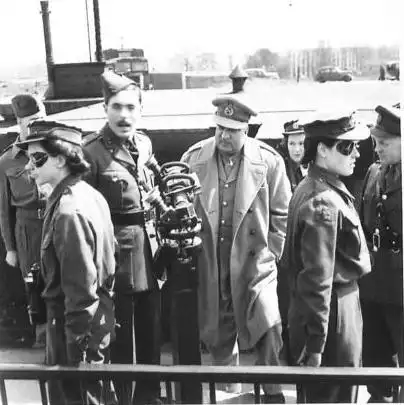 Black-and-white photograph of military officers and personnel gathered at a port during the mid-20th century